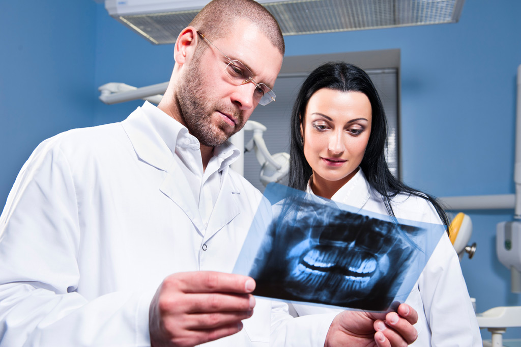 Dentist and assistant checking x-ray at dental clinic
